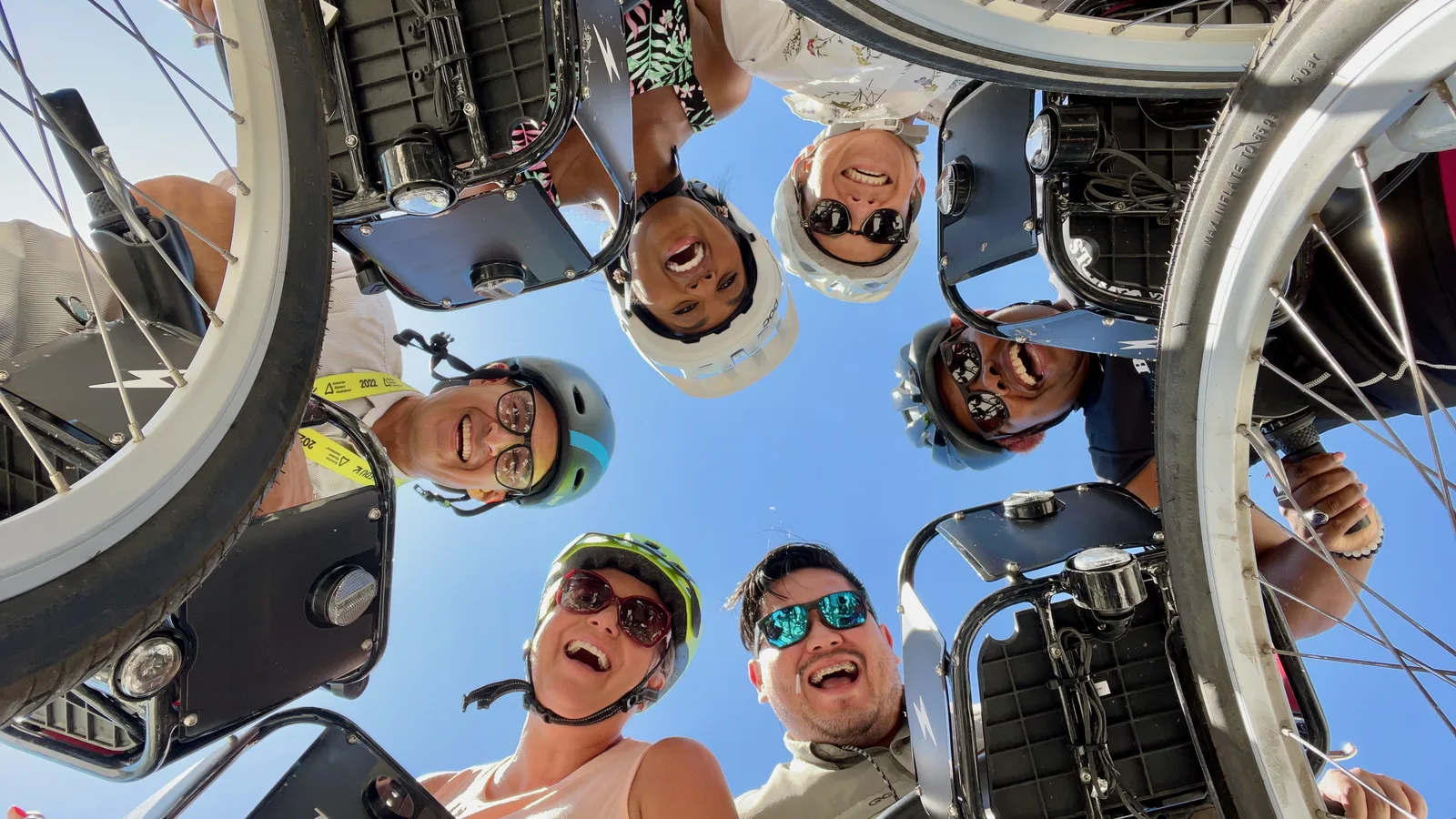 a group of people with a bike share bicycles looking down on a camera