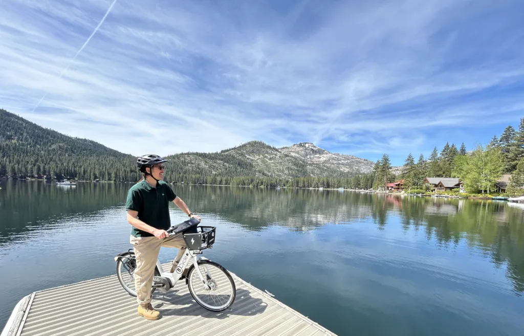 man riding a bike share bicycle by Lake Tahoe admiring the view
