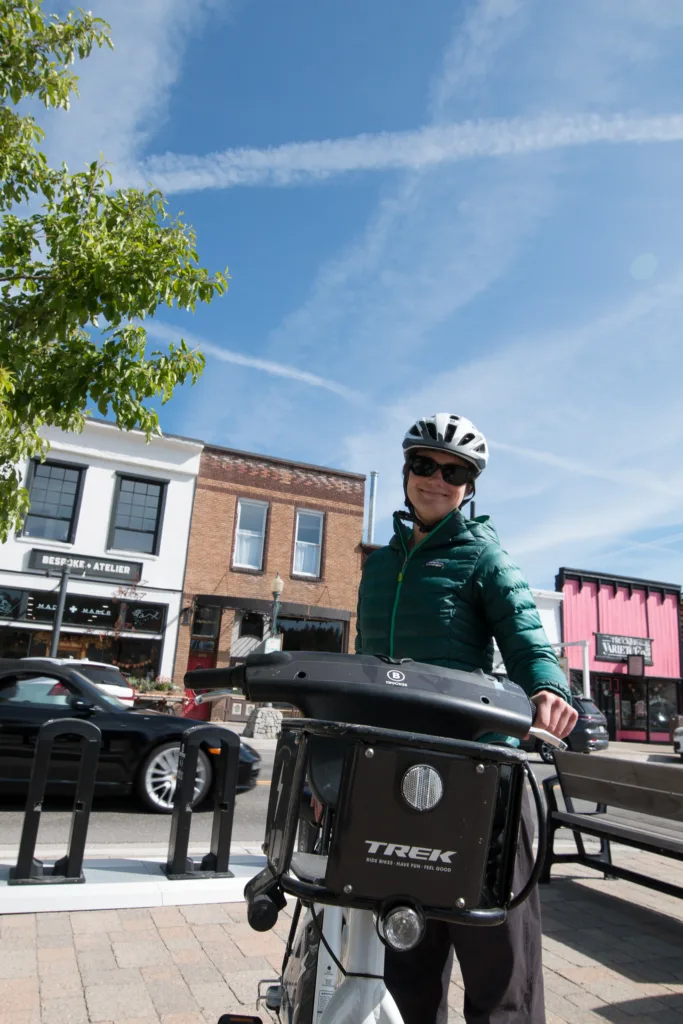 Woman with her bike share bicycle next to a docking station
