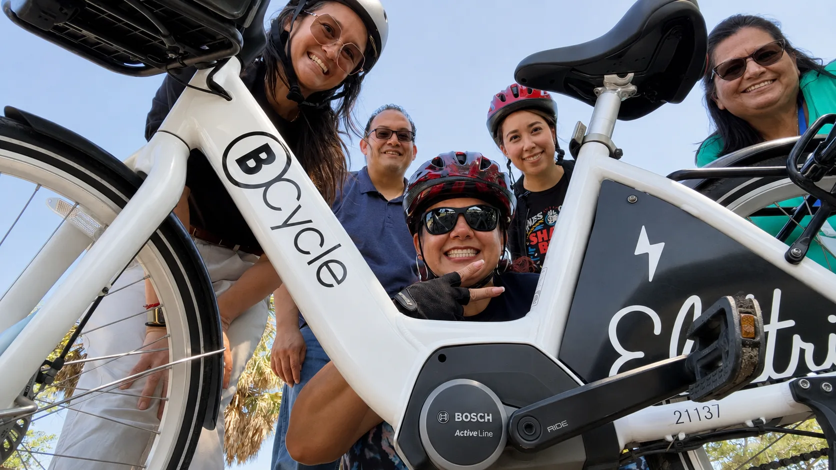group of people taking a selfie with a bike share bicycle